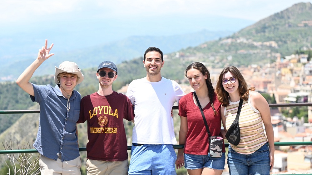 Students pose in front of vista in Sicily